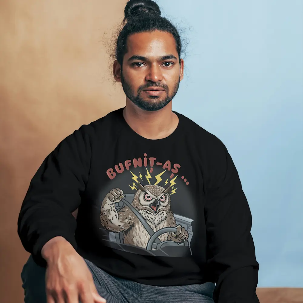 Bărbat purtând bluză neagră cu bufniță la volan, fulgere și mesaj „Bufnit-aș…”.